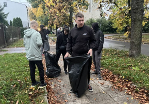 Wychowankowie idą z workami na śmieci