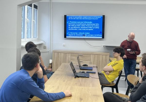 Siedmiu wychowanków ogląda prezentację multimedialną dotyczącą tego jak rozpoznawać zagrożenia w Internecie