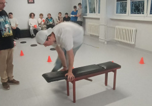 Wychowanek przeskakuje ławeczkę.