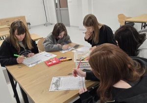 Przy stole siedzą dziewczynki I opisują swoją mamę