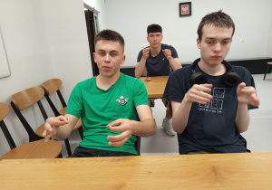 Wychowankowie pokazują znak migowy auto.