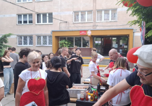 Kilkanaście osób dziewcząt i chłopców stojących w kolejce do degustacji.