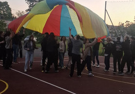 Chłopcy i dziewczęta bawią się chustą animacyjną