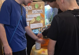 Trzech chłopców wrzucają do słoika karteczki