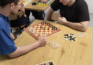 Dwóch wychowanków rozgrywa partie gry w szachy.