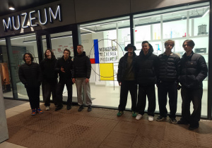 Chłopcy stoją przed muzeum.