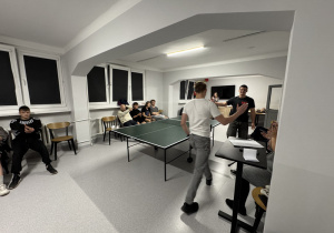 Dwóch wychowanków zakończyło rozgrywkę, gratulują sobie wzajemnie i podają sobie dłonie, reszta osób klaszcze.