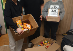 Trzech chłopców prezentuje zawartość paczek