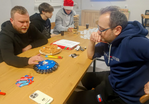 Dwóch wychowawców gra w alfabetów wyzwanie, a za nimi dwóch wychowanków gra w grę Jenga.