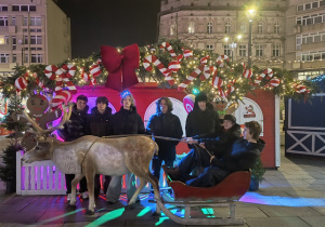 Chłopcy stoją przy reniferze